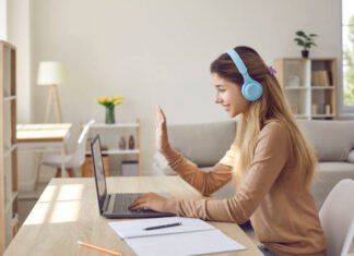 Girl wearing headphones engaging in online PTE classes on Laptop