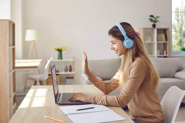 Girl wearing headphones engaging in online PTE classes on Laptop